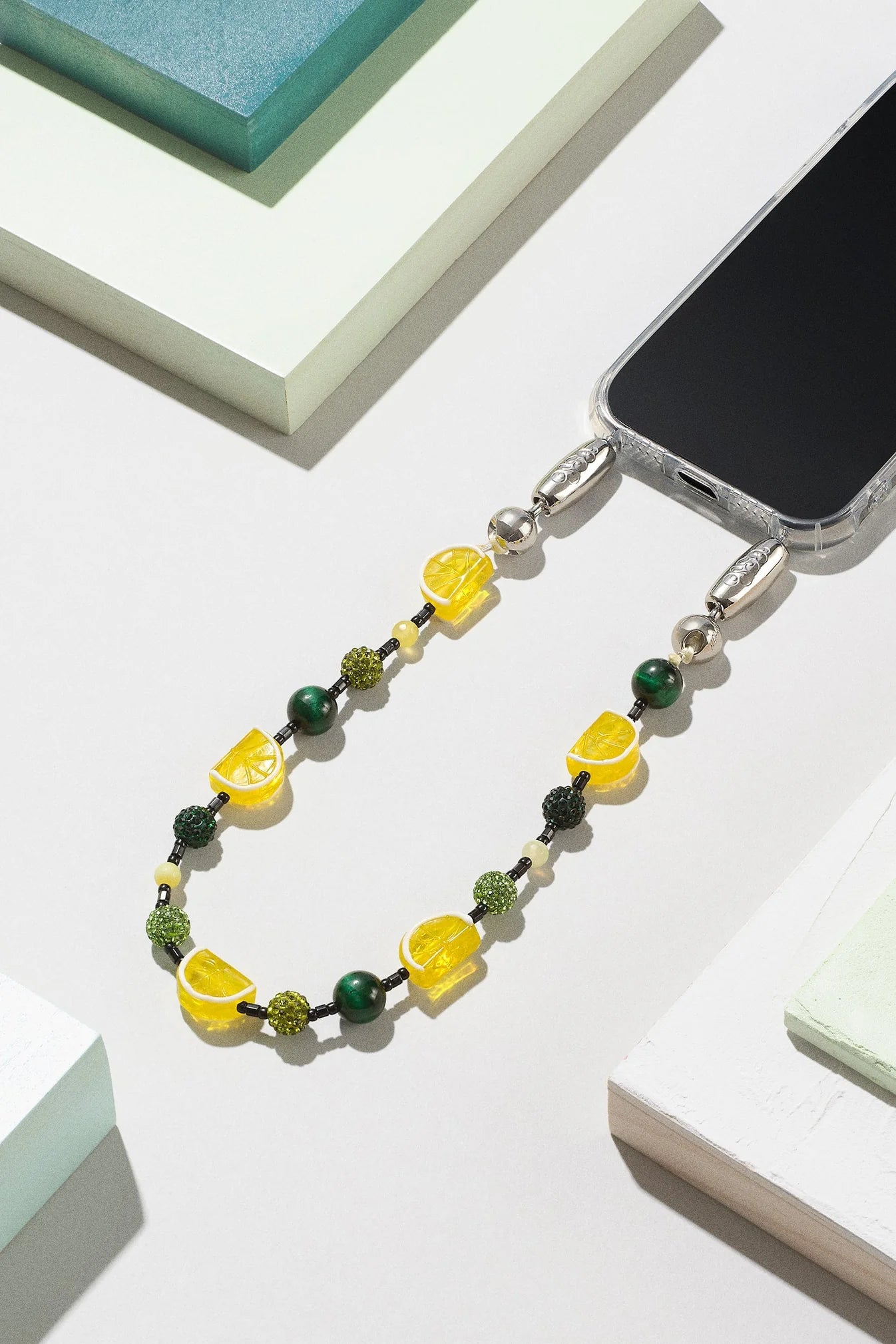 Ossa New York Fruit Wristlet phone strap featuring genuine gemstone beads and high tempered glass fruit charms on durable nylon cord.