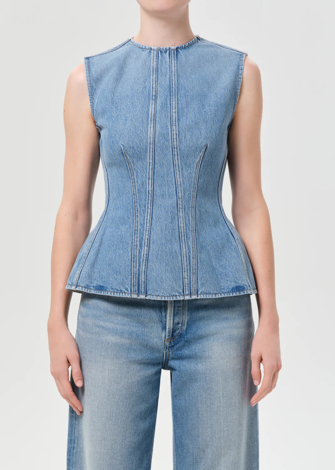 AGOLDE Corbin sleeveless denim peplum top in Danton medium vintage indigo wash with structured seams.
