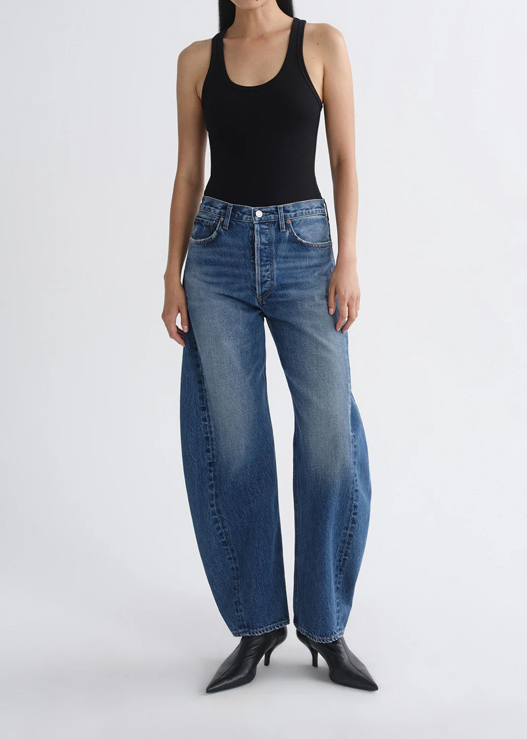 AGOLDE Luna high-rise tapered jeans in Logical medium blue denim with sculptural curved legs and pieced panel stitching.