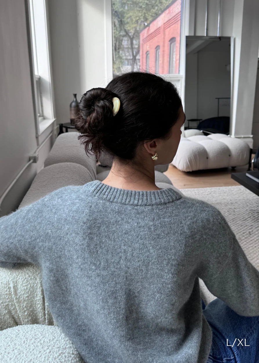 Model using a French Pin to secure a classic French twist updo