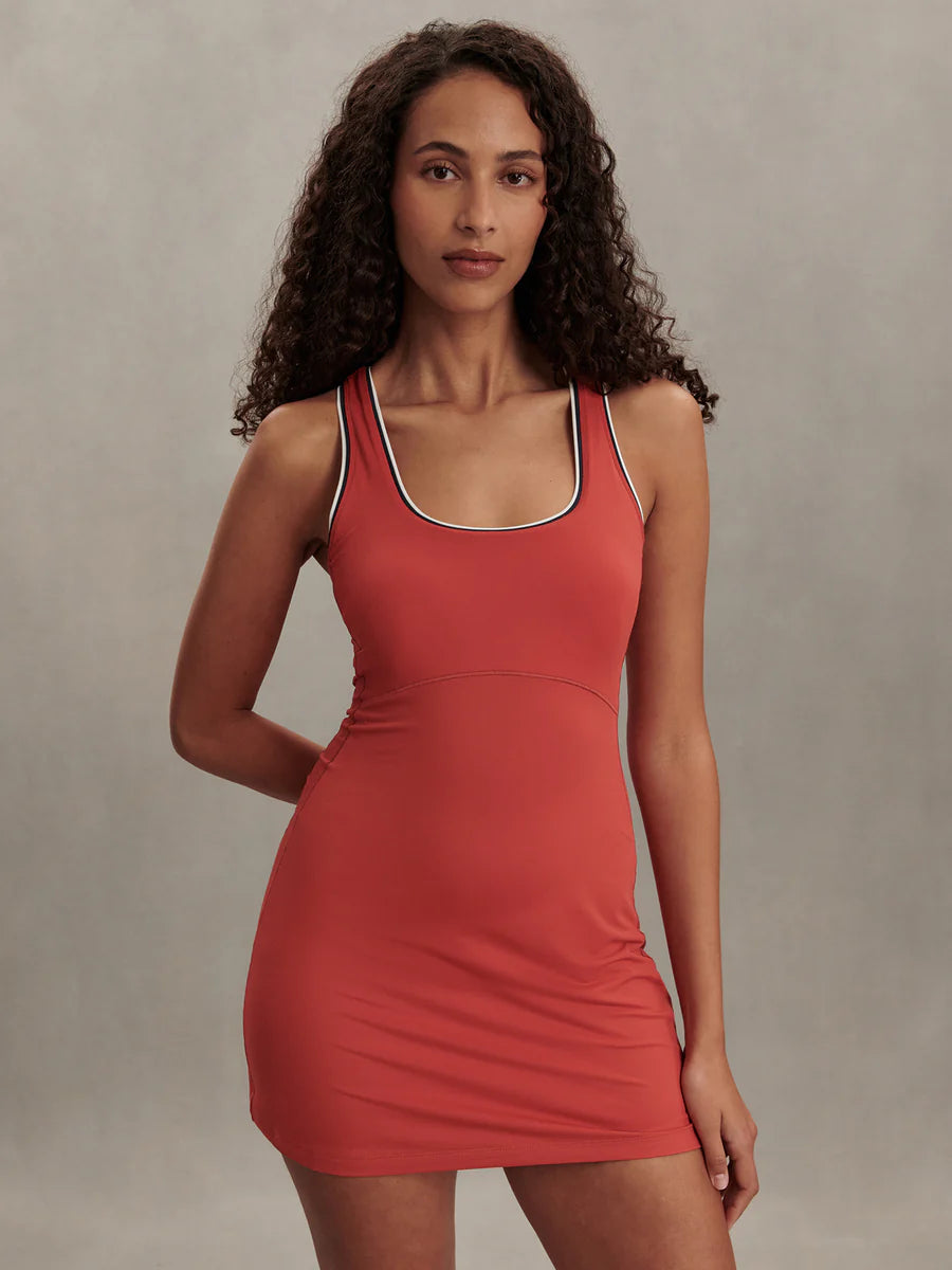 Varley Ruan active court dress in Baked Apple red Smooth Touch stretch jersey featuring built-in shorts and piping details.