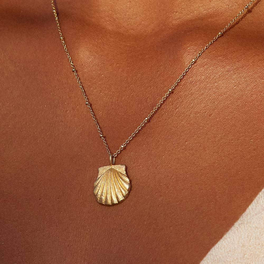 Agapée Milos gold necklace with a detailed shell pendant and satin finish