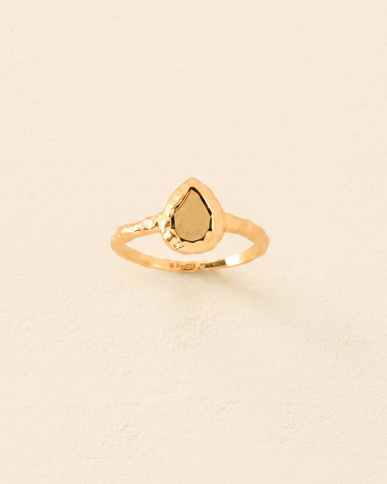 Agapée Lysia textured 18K gold-plated ring featuring a drop-shaped dark green stone in a raw bezel setting.
