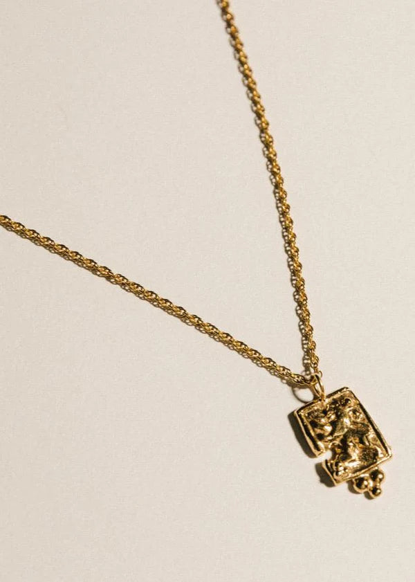 Pamela Card fractured gold amulet necklace featuring a hand-carved lioness and beaded pyramid detail.