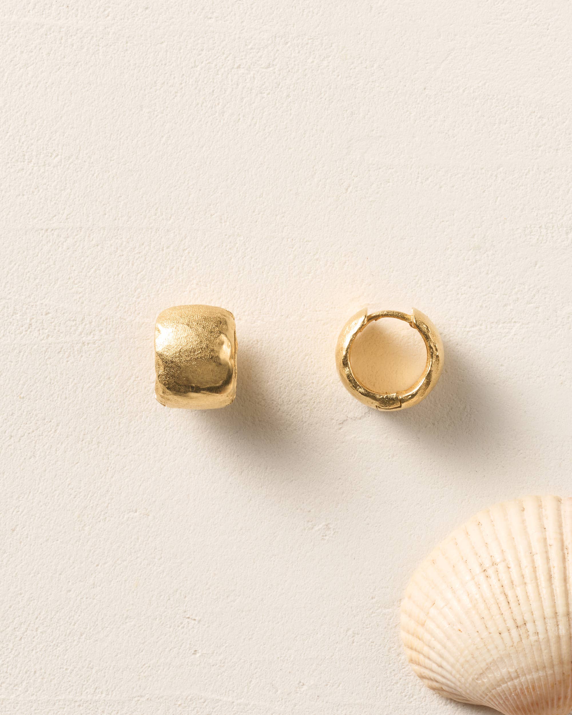 Agapée Juno sculptural wide huggie hoop earrings featuring a rich gold-plated hammered finish.