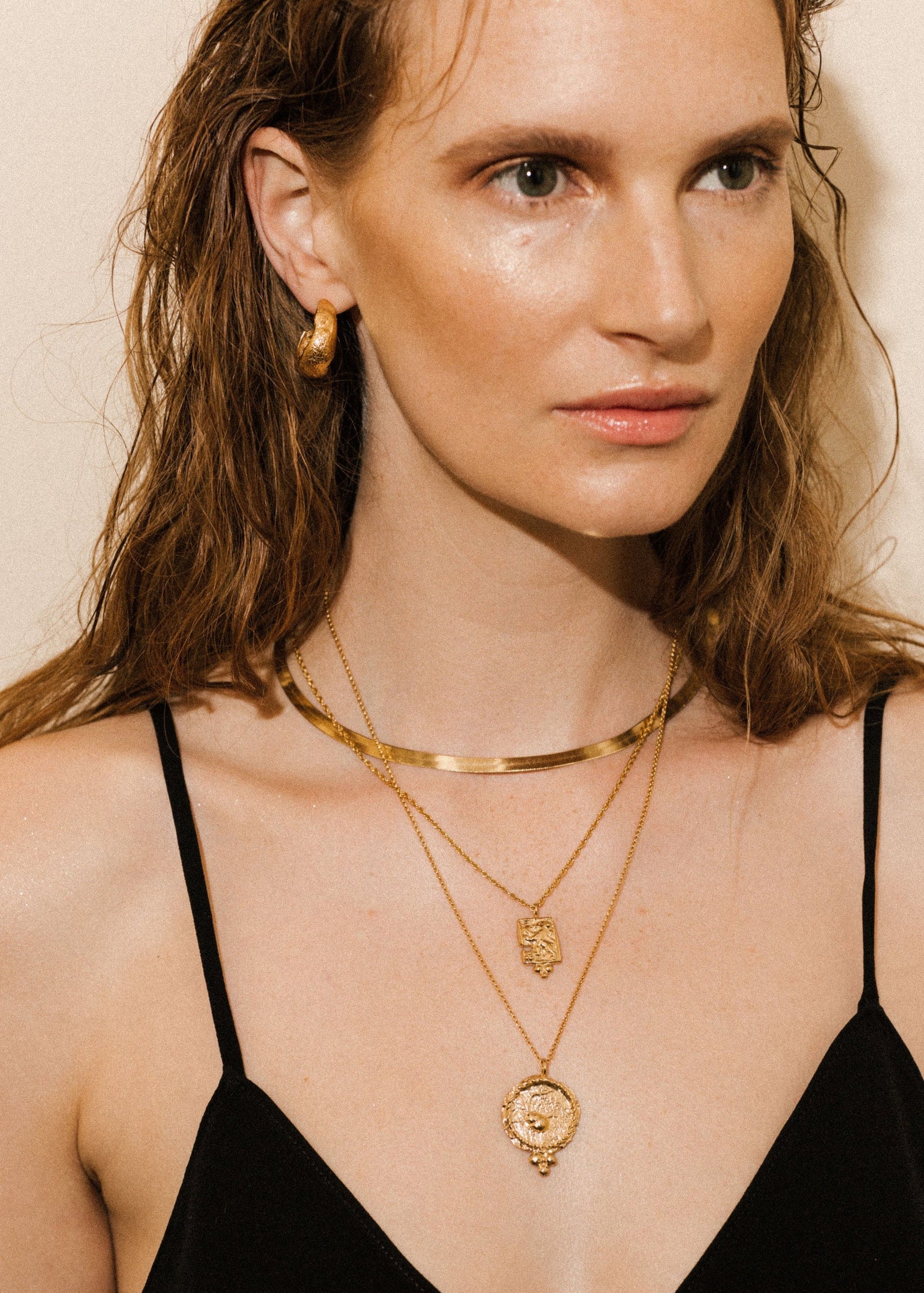 Pamela Card fractured gold amulet necklace featuring a hand-carved lioness and beaded pyramid detail.