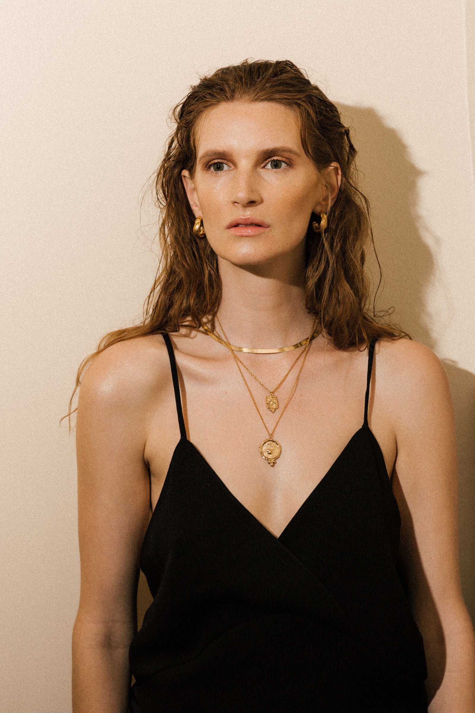Pamela Card fractured gold amulet necklace featuring a hand-carved lioness and beaded pyramid detail.